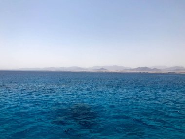Manzara periling tuzlu deniz suyu, deniz, okyanus dalgaları, dalgaların uzak dağ zemin karşı kavurucu güneşin altında ile şeffaf mavi.