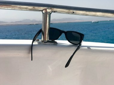 Beryl gemiye bir turistik gemi, yat ve yelkenli, tekne, liner tesiste, denizde bir tropikal mavi gökyüzü arka plan siyah koruyucu güneş koruyucu plastik gözlük dayan.