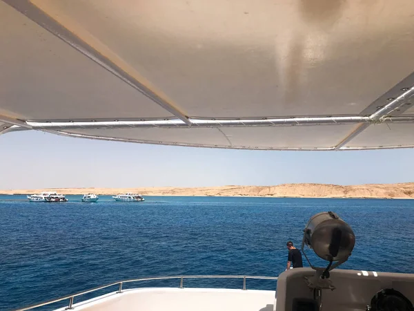 Güzel bir manzara, mavi deniz ve uzak sarı kum dağların yandan görünümünü, beyaz bir kutu, bir tekne, bir cruise liner bir projektör ile kabinler.