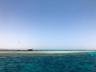 Tropik sahil beldesi ve bir gemi, bir tekne, bir tanker ve bir helikopter enkazı sitede mavi tuz deniz manzaralı güzel bir deniz manzarası.