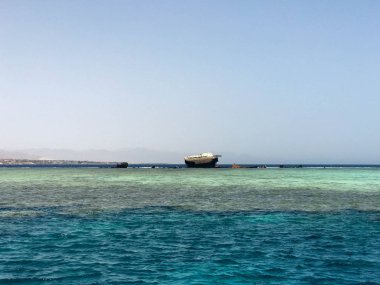 Tropik sahil beldesi ve bir gemi, bir tekne, bir tanker ve bir helikopter enkazı sitede mavi tuz deniz manzaralı güzel bir deniz manzarası.