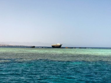 Tropik sahil beldesi ve bir gemi, bir tekne, bir tanker ve bir helikopter enkazı sitede mavi tuz deniz manzaralı güzel bir deniz manzarası.