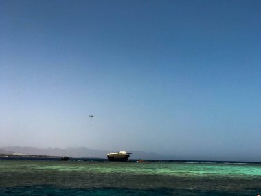 Tropik sahil beldesi ve bir gemi, bir tekne, bir tanker ve bir helikopter enkazı sitede mavi tuz deniz manzaralı güzel bir deniz manzarası.