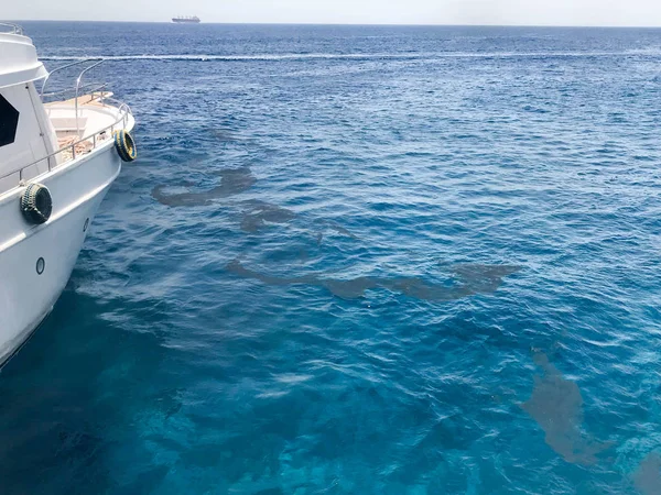 Yay, beyaz gemi yan ve su birikintileri, petrol sızıntıları, kirli sıvı, ekolojik mavi tuz deniz, tropik sahil beldesi okyanusta görünümünü