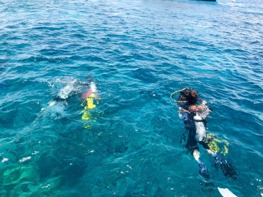 Dalgıçlar ile parlak metal alüminyum kutu kayan nokta, siyah dalış su geçirmez giyen tatil, tropikal ülkelerde deniz cruise mavi deniz suyu dalış.