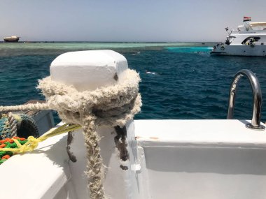 Bir beyaz güçlü bez halat, bir gemi, bir tekne, bir bağlantı için bir deniz tropikal sıcak egzotik tatil mavi deniz kenarına bağlı bir ip.