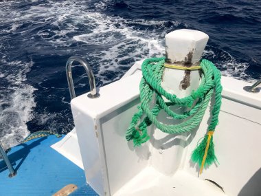 Yeşil güçlü dayanıklı kalın kumaş gemi halatı bir ip yatak, kayan bir gemi, bir tekne mavi denize karşı bağlı bir durdurmak için.