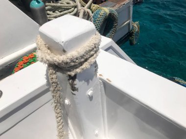Beyaz güçlü dayanıklı kalın kumaş gemi halatı, bir ip tekne, gemi, tekne arka plan mavi denizin üzerinde bağlı bir stop için.