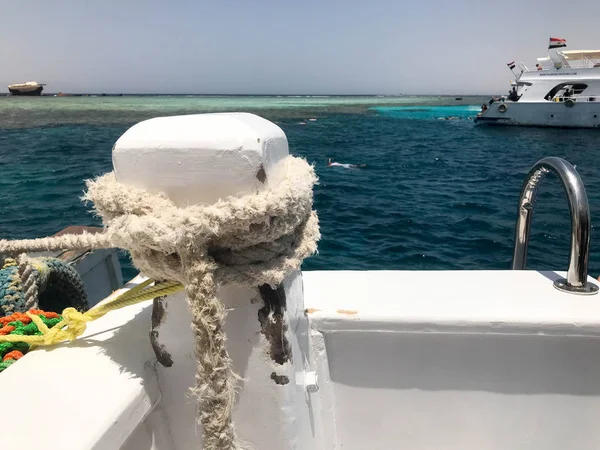 Bir beyaz güçlü bez halat, bir gemi, bir tekne, bir bağlantı için bir deniz tropikal sıcak egzotik tatil mavi deniz kenarına bağlı bir ip.