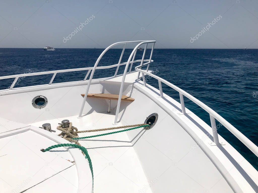 The nose of the ship, the bow of the floating ship, the cruise liner, the yacht, the boat on the background of the blue salt sea, the ocean on the tropical sea warm resort, rest and copy space.