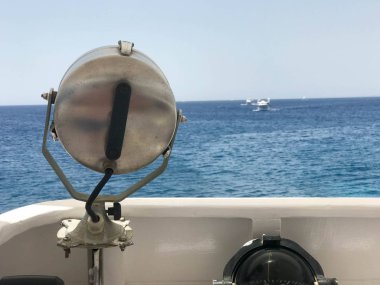 Projectoa, güçlü bir lamba, ferrimous metal m güçlü lamba keçiboynuzu deniz, okyanus, su arka plan üzerine monte.