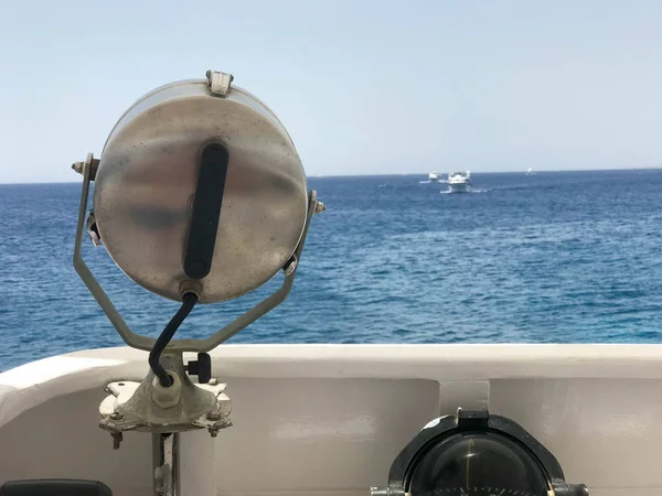 Projectoa, güçlü bir lamba, ferrimous metal m güçlü lamba keçiboynuzu deniz, okyanus, su arka plan üzerine monte.