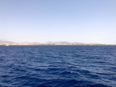 Uzak güzel kahverengi taş dağlar ve mavi tuz Azure deniz, okyanus mavi gökyüzüne karşı deniz manzara.