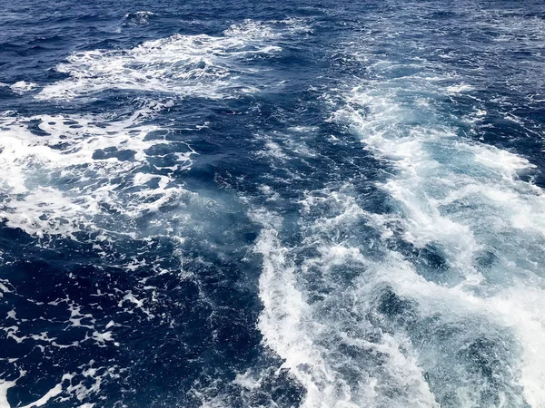 一个沸腾的蓝色海水的纹理与波浪 飞溅后 快速浮动车 — 图库照片