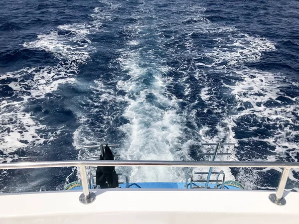 İçten içe kaynıyordu mavi doku deniz tuzlu su ile dalgalar, dökülmeleri, bubbles, köpük hızlı bir kayan sepeti sonra bir tekne. Arka plan.