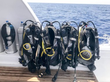 Siyah dalgıç giysisi hortumlar ve hızlı hareket eden bir teknede bir stand üzerinde asılı dalgıçlar ile bir sürü gemi, cruise liner bir tropikal tatil.