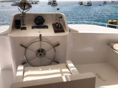 Tamam bir gemi, tekne, cruise gemisi ile direksiyon simidi, kontrol paneli ile deniz pusula ve mavi deniz ve gemi gökyüzü altında karşı kontrol için aygıtlar.