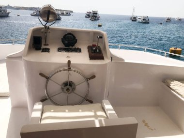 Tamam bir gemi, tekne, cruise gemisi ile direksiyon simidi, dashboard, koltuk, deniz pusula ve arka planı mavi tropikal deniz ve gemi kontrol için aygıtlar.