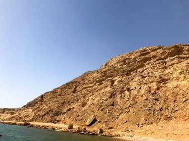 Büyük bir güzel görkemli dağ taş kumlu, bir höyük, bir tepe, mavi gökyüzü ve denizin karşı çölde bir tepe. Manzara.