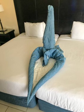 Geri çekilmeli yatak ve kalp figürü ve battaniyelerden yapılmış bir kuğu, tropikal sıcak egzotik bir ülkede tatil yatak örtüleri ile bir odada Oda Servisi, tatil.