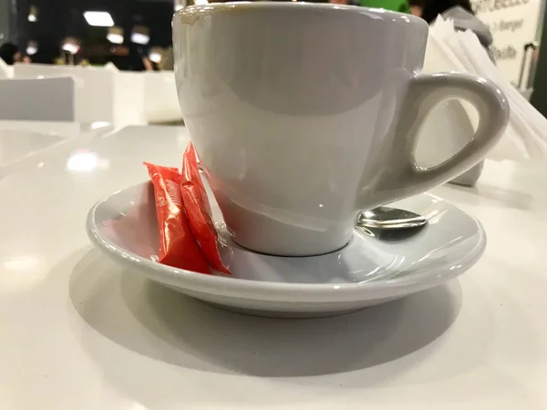 Una taza de cerámica de vidrio blanco, una taza de té, café, una bebida caliente está en una mesa en un café — Foto de Stock