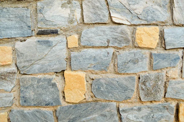 Texture of a stone wall, roads from stones, bricks, cobblestones, tiles with sandy seams of gray ancient natural old yellow with sharp edges. The background — Stock Photo, Image