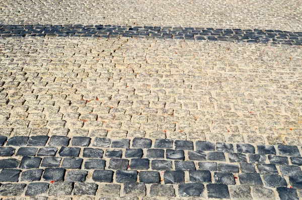 Textur einer Steinmauer, Straßen aus Steinen, Ziegeln, Kopfsteinpflaster, Fliesen mit sandigen Nähten von grauen alten natürlichen alten gelb mit scharfen Kanten. der Hintergrund — Stockfoto