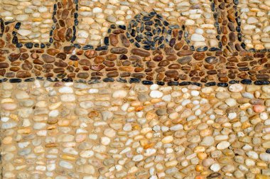 The texture of the stone wall, the road from small round and oval stones with abstract lines laid out patterns of sandy seams of natural old yellow black brown. The background clipart