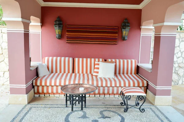 Sofá suave en una cafetería al aire libre en la calle y una mesa para el té en estilo árabe con arcos — Foto de Stock