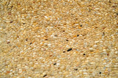 Taştan bir duvar dokusu, kum dikişleri doğal eski sarı siyah Brown ile küçük yuvarlak ve oval taşlarla yollardan. Arka plan