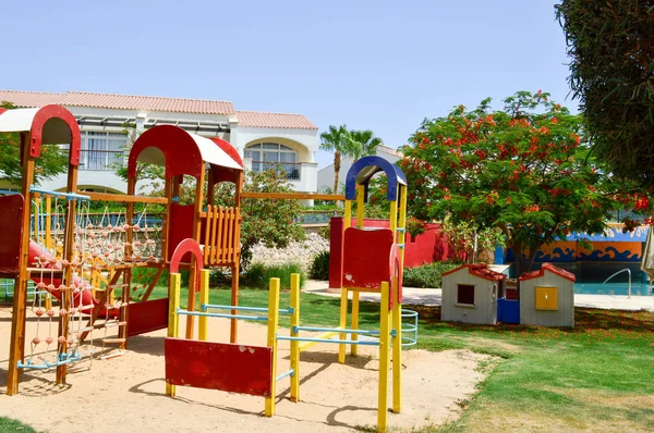 Um parque infantil alegre com escorregas de poças de areia jogando jogos e desenhos em uma exótica estância tropical quente férias país — Fotografia de Stock