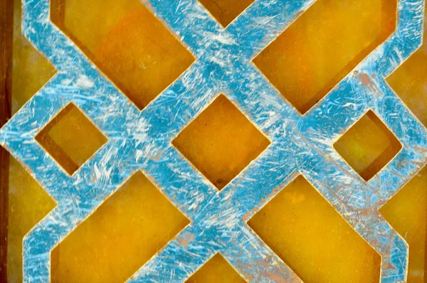 Textura de un patrón árabe abstracto rayado azul de barras de hierro de metal, líneas sobre un fondo amarillo anaranjado. El trasfondo — Foto de Stock