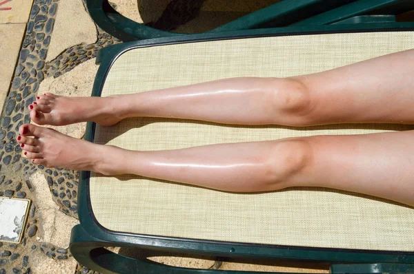 Pernas bonitas, pés de meninas, mulheres com manicure vermelho no fundo de uma cadeira de praia e piscina em uma estância balnear exótica quente tropical, férias de verão — Fotografia de Stock