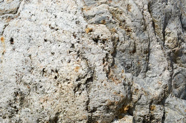 Texture of natural natural carved solid strong rough rough sharp textured mineral gray brown stone cobblestone on the walls of the rock. Stone background — Stock Photo, Image