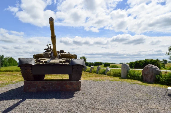 En stor grön militär metall bepansrade dödligt farliga järn ryska syriska stridsvagn med en kanontorn och en gås är parkerad parkerade mot en blå himmel och moln utanför staden — Stockfoto