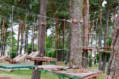 Tırmanma duvarı, troller ve halat Parkı doğa ormanda çocuklar ve yetişkinler oynamak için halatlar ile Oyunlar ve eğlence panoları ve ağaçlar için spor vardır