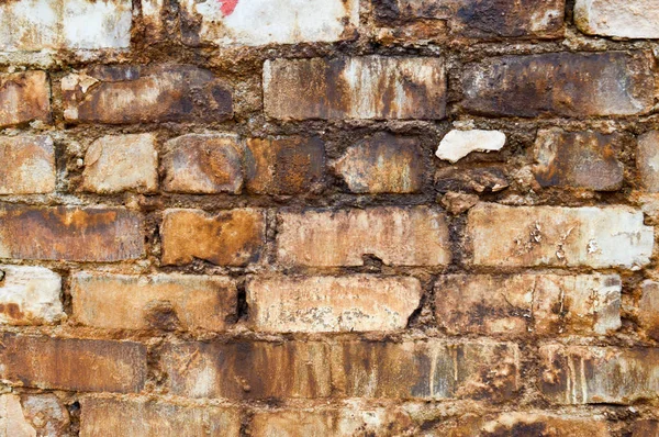 Textur aus Ziegeln aus einer alten Ziegelmauer mit Nähten mit schmutzigen Streifen von Flicken elend hässlich alt. der Hintergrund — Stockfoto