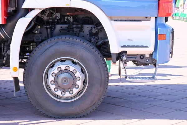 Une grande roue en caoutchouc noir avec un couvercle de camion avec un disque métallique et des éléments de suspension de voiture — Photo