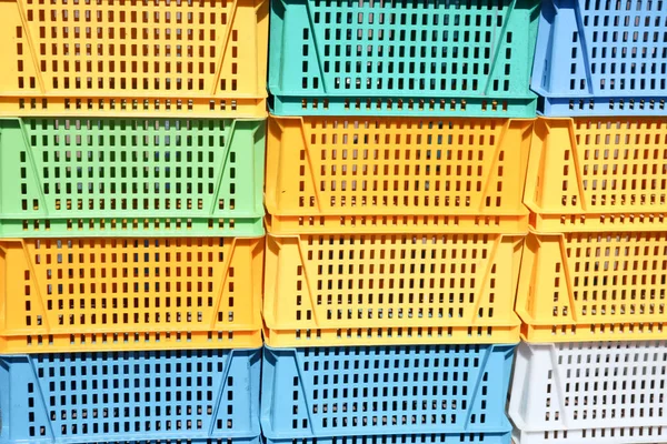 Texture from colored plastic colored yellow blue green rectangular boxes with holes for goods, bottles
