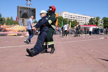 Erkekler itfaiyeci yanmaz elbise ve kask kurtarmak sürükler içinde yangınla mücadele-yarışmalar, Minsk, Beyaz Rusya, 06.06.2018, egzersizleri, işçinin adamın tehlikeden maniken çeker