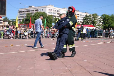 Erkekler itfaiyeci yanmaz elbise ve kask kurtarmak sürükler içinde yangınla mücadele-yarışmalar, Minsk, Beyaz Rusya, 06.06.2018, egzersizleri, işçinin adamın tehlikeden maniken çeker