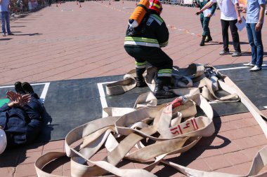 Yangına dayanıklı siyah elbiseli adamlar ateş ve bir balon bir kask ile hortumları, yangın hortumları insanları kurtarmaya çalışır