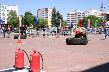 Bir itfaiyeci yanmaz elbise giyip kask içinde çalışır ve rekabet, Belarus, Minsk, 08.08.2018 mücadele yangında büyük lastik tekerlek dönüyor