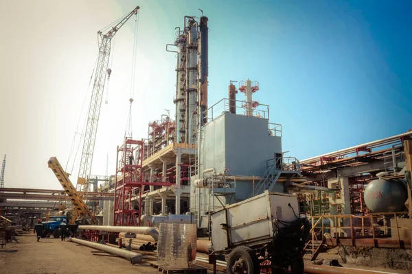 Lugar de construcción para la construcción de una refinería de petróleo con columnas de rectificación, intercambiadores de calor una grúa en una refinería de petróleo — Foto de Stock
