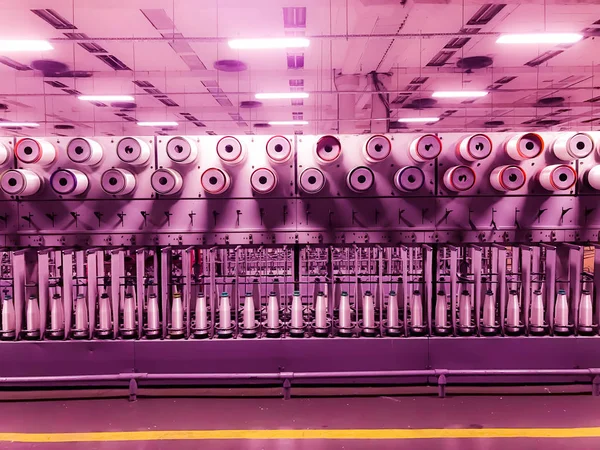 Makara ile sentetik iplik. Bobinler fiberglas ile. Cam elyaf imalatı. Fabrika fiberglas üretimi için