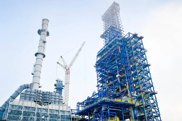 Construction with cranes of a large blue chemical plant at an oil refinery, petrochemical plant — Stock Photo, Image
