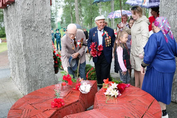 Old man grandfather veteran of World War II in medals and decorations puts cents in a sign of respect for the monument on Victory Day Moscow, Russia, 05.09.2018 Royalty Free Stock Images