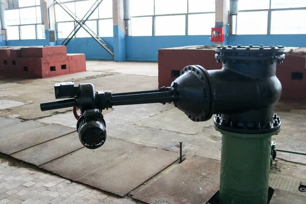 Uma grande válvula de metal preto portão de ferro com um acionamento elétrico em uma planta industrial — Fotografia de Stock