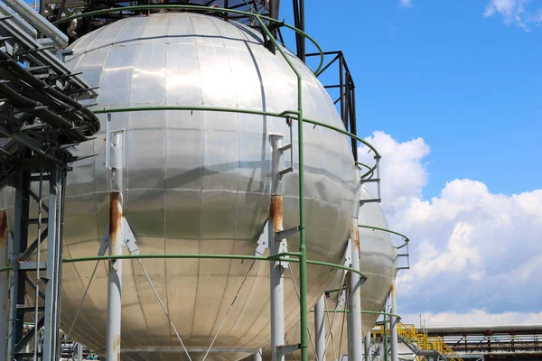 Duży okrągły piłka wymodelowany błyszczące metalowe pod wysokim ciśnieniem żelaza zbiornik amoniaku jest silny, z rur i urządzeń w rafinerii przemysłu petrochemicznego, chemicznego rafinerii — Zdjęcie stockowe