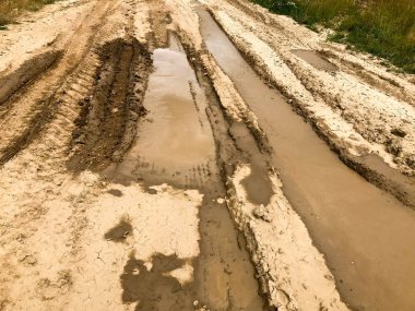 Kirli, pis, çamurlu, çamurlu, çamurlu, çatlak ve tekdüze çamurlu toprak bir yol. Off-road. Arkaplan